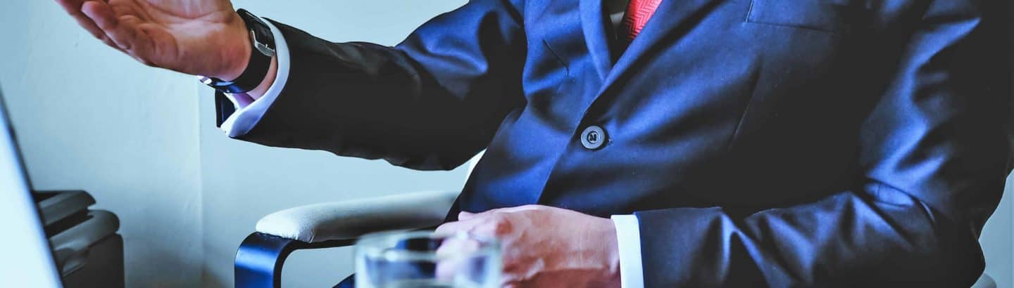 Verhandlungsdolmetscher im blauen Anzug vor Laptop